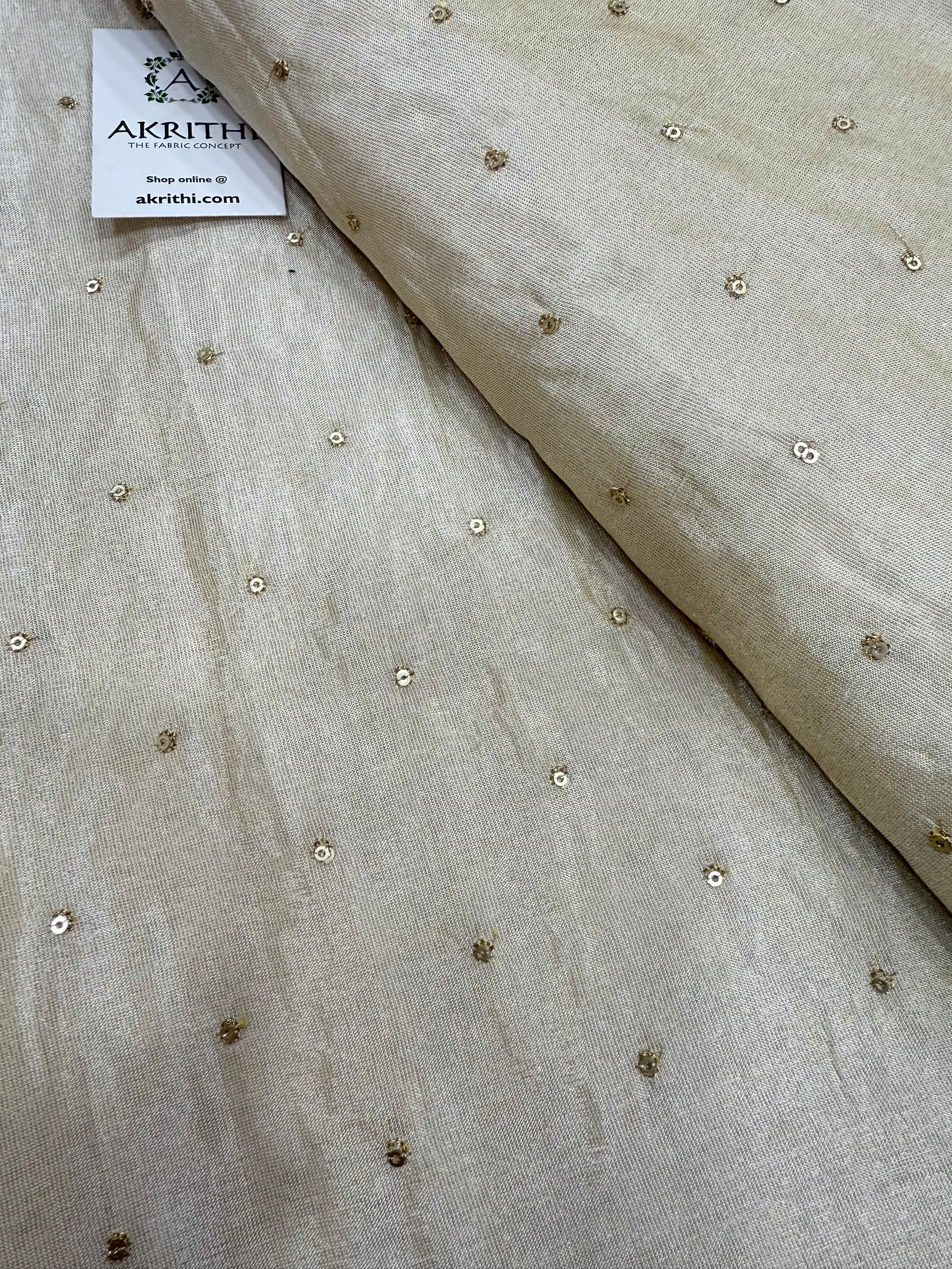 Sequins on dyeable tissue fabric