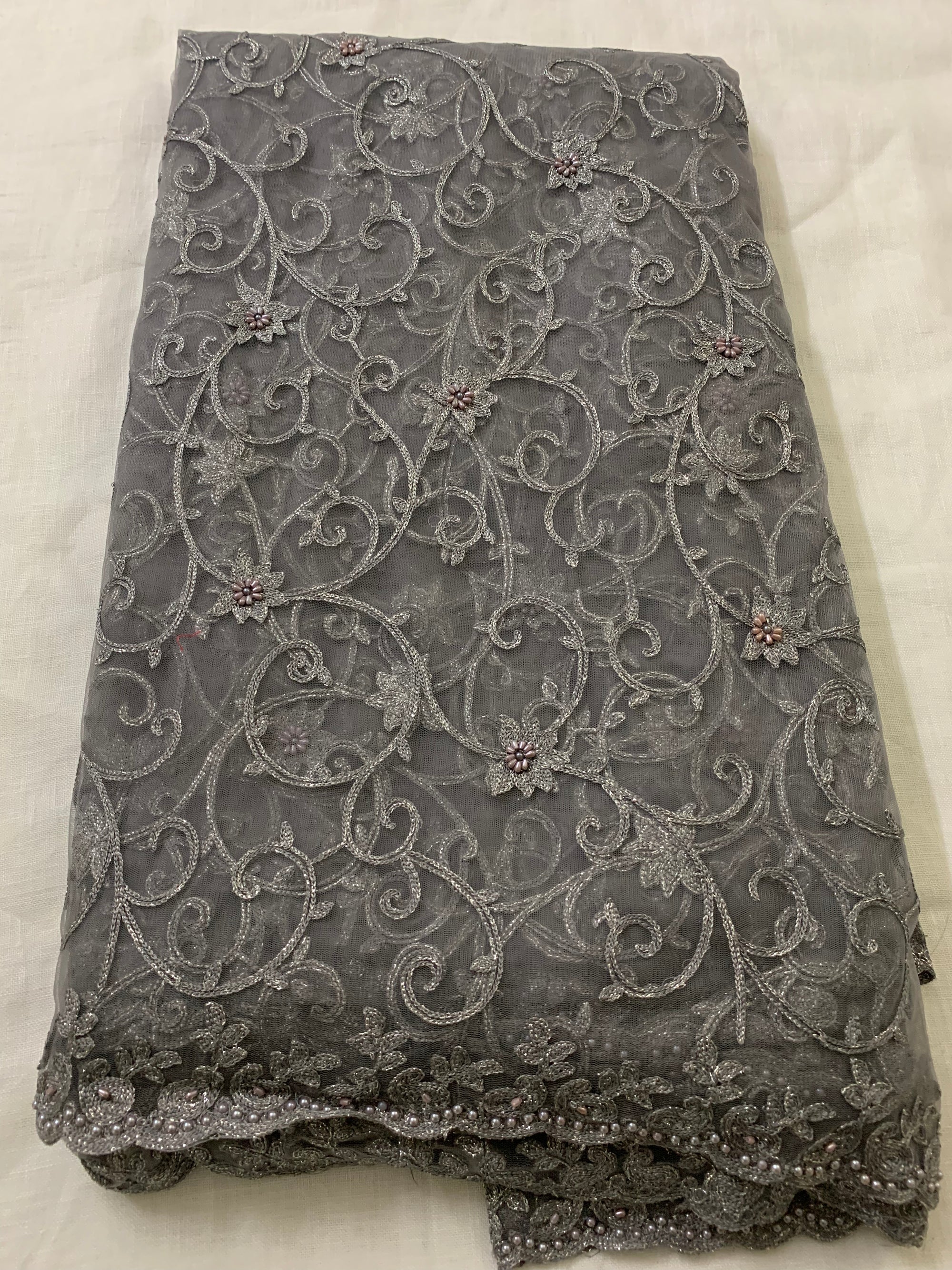 Embroidery on charcoal grey net fabric