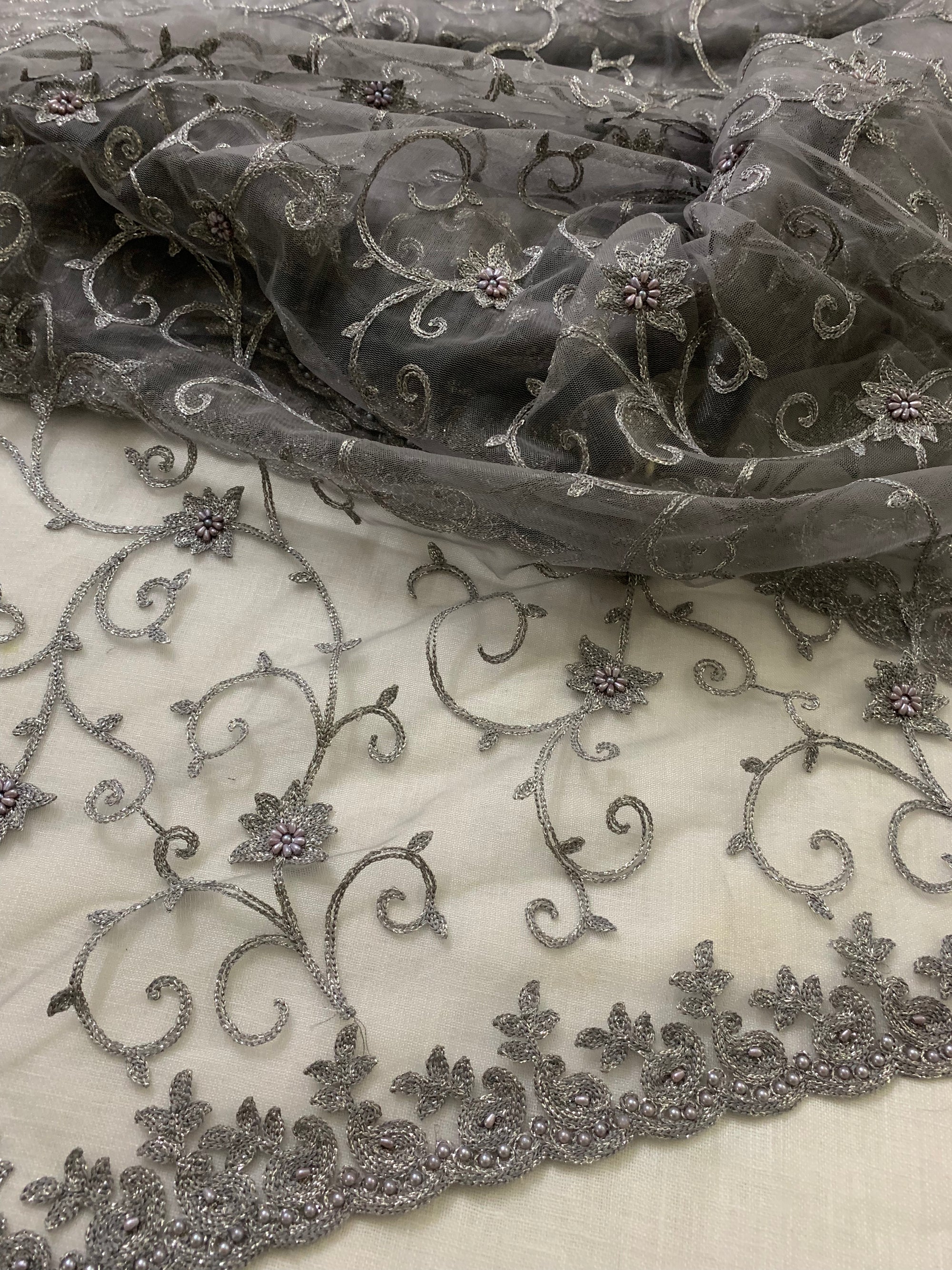 Embroidery on charcoal grey net fabric