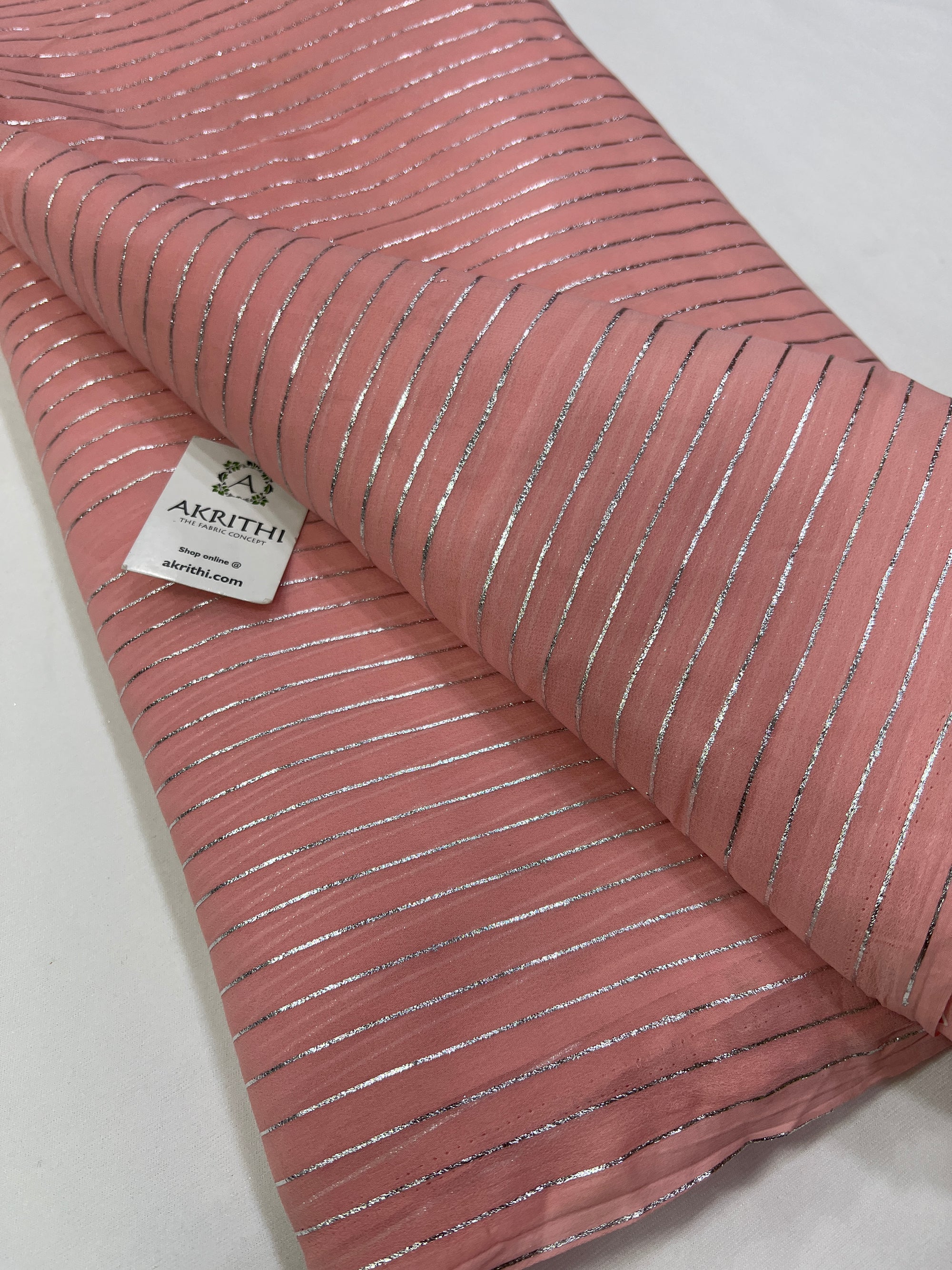 Foil printed pinkish peach georgette fabric