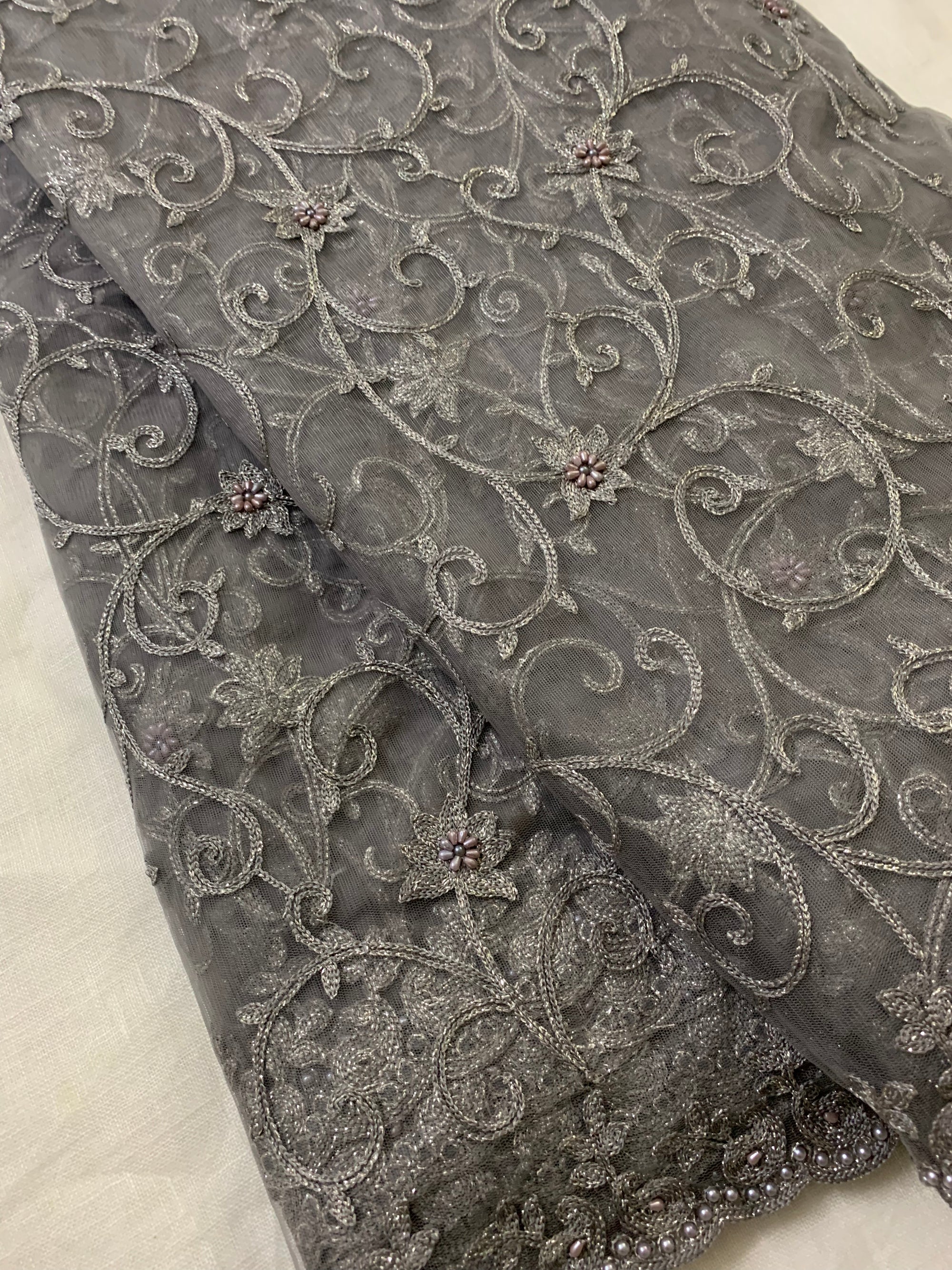 Embroidery on charcoal grey net fabric