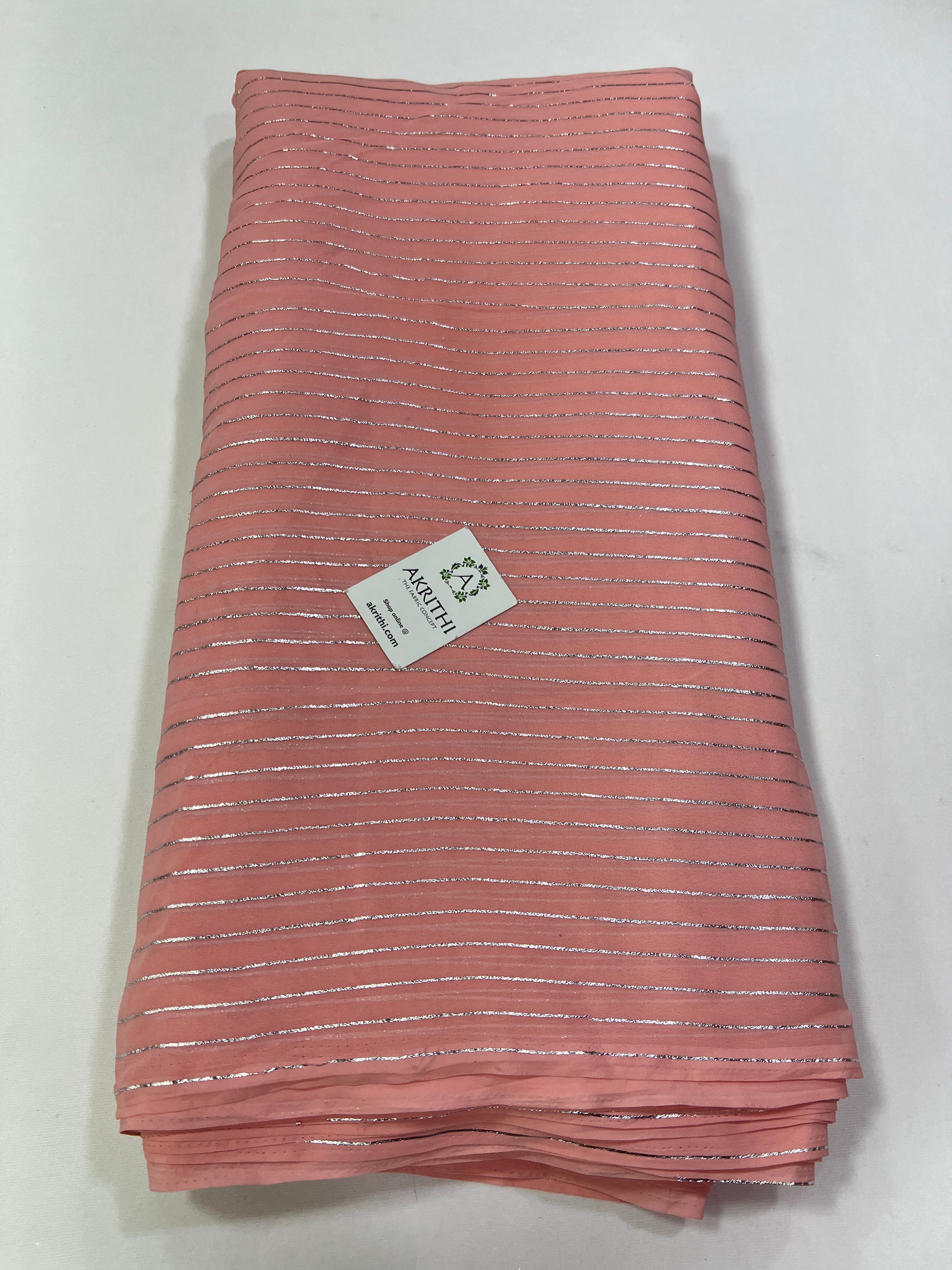 Foil printed pinkish peach georgette fabric